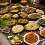 People serving themselves at a crowded buffet table.